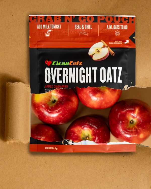 Clean Eatz Overnight Oatz Apple Cinnamon grab-n-go pouch with red apples pictured through the front window on a tan background.