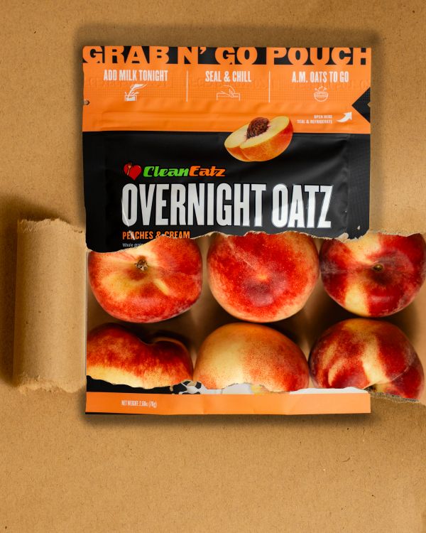 Clean Eatz Overnight Oatz Peaches & Cream grab-n-go pouch with fresh peaches pictured through the front window on a tan background.